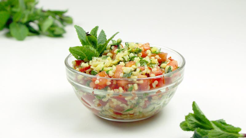 Insalata di tabulé in una ciotola di vetro su un fondo bianco fotografie stock Insalata di tabulé in una ciotola di vetro su un fondo bianco fotografie stock