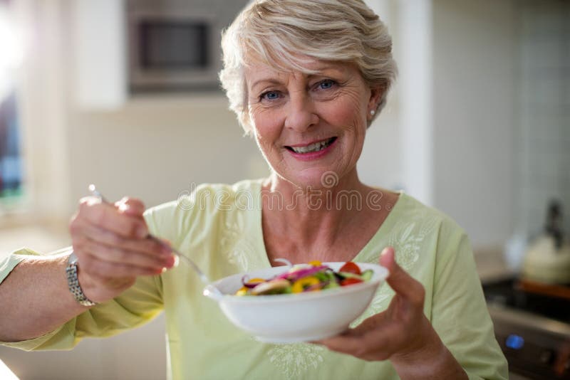 Insalata di verdure della tenuta senior della donna in ciotola fotografia stock libera da diritti Insalata di verdure della tenuta senior della donna in ciotola fotografia stock libera da diritti