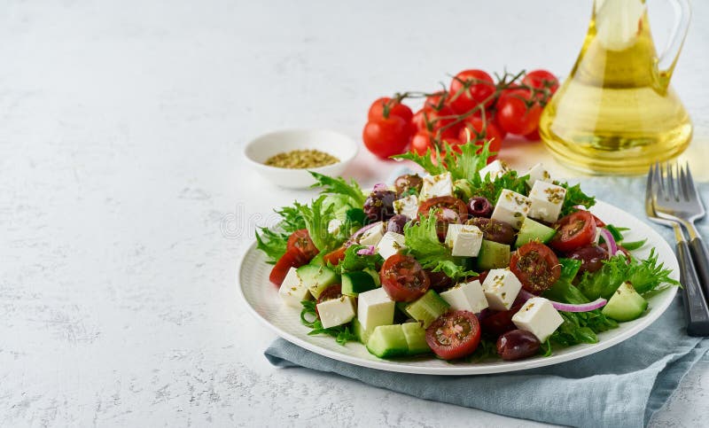 Greek Salad with feta cheese, olives, cherry tomato, cucumber, lettuce and onion, vegeterian mediterranean food, low calories dieting meal. Greek Salad with feta cheese, olives, cherry tomato, cucumber, lettuce and onion, vegeterian mediterranean food, low calories dieting meal