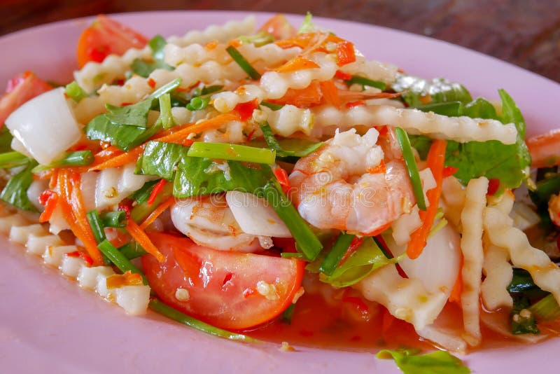 Insalata piccante del tiro della noce di cocco e del gamberetto sul piatto rosa immagine stock libera da diritti Insalata piccante del tiro della noce di cocco e del gamberetto sul piatto rosa immagine stock libera da diritti