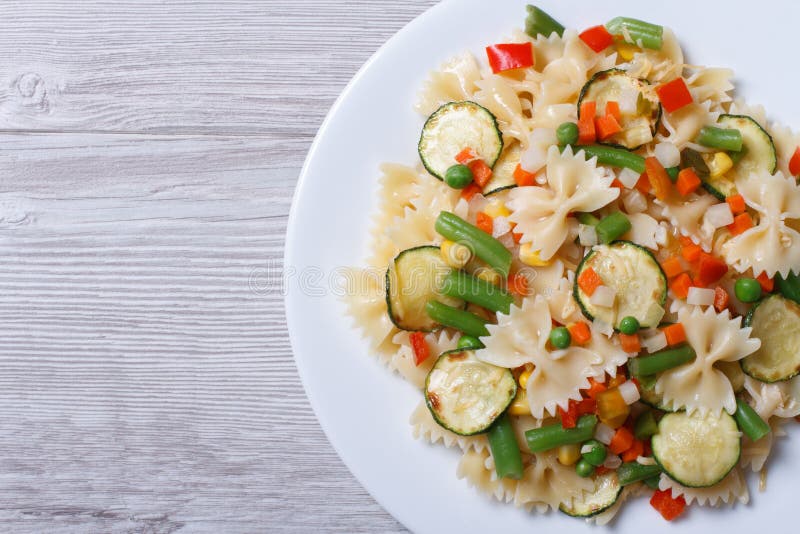 Insalata saporita della pasta del farfalle con la vista superiore del primo piano delle verdure fotografie stock libere da diritti Insalata saporita della pasta del farfalle con la vista superiore del primo piano delle verdure fotografie stock libere da diritti