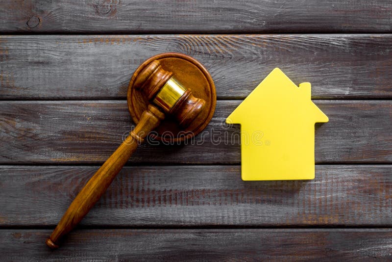 Inscribed gavel, house figure for inheritance concept on wooden background top view.