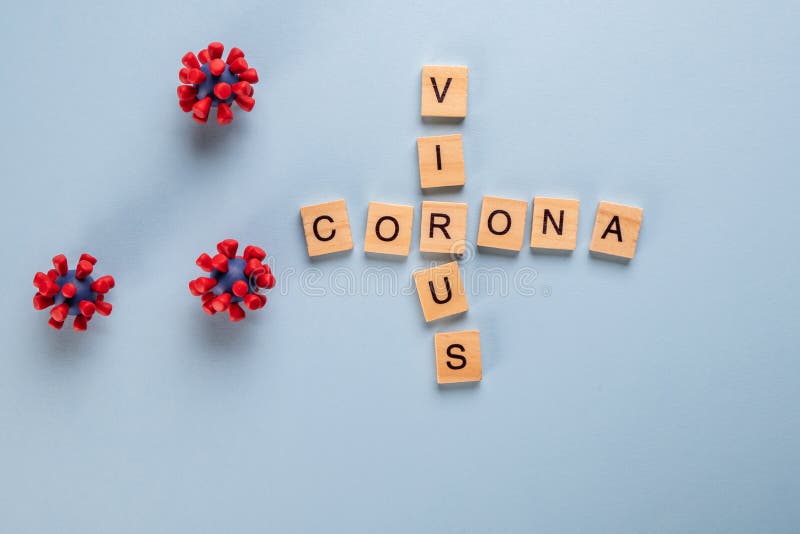 Inscription coronavirus made up of wooden letters on blue background and models of covid-19 virus.Virus pandemic  protection concept