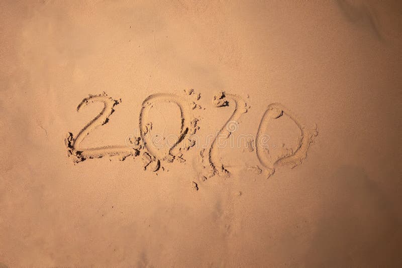 Inscription with a finger on the sand. Figures happy new year 2020.  royalty free stock photo