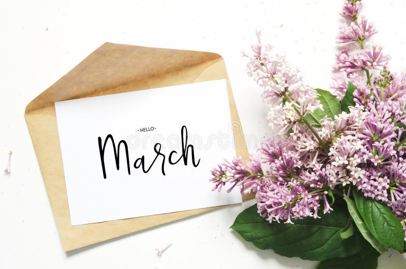 Inscription Hello March. Lilac flowers and envelope on white background. Spring flowers. Top view, flat lay. stock photo Inscription Hello March. Lilac flowers and envelope on white background. Spring flowers. Top view, flat lay. stock photo