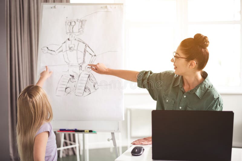 Insegnante allegro e bambino che mostrano sull'immagine del robot immagine stock libera da diritti Insegnante allegro e bambino che mostrano sull'immagine del robot immagine stock libera da diritti