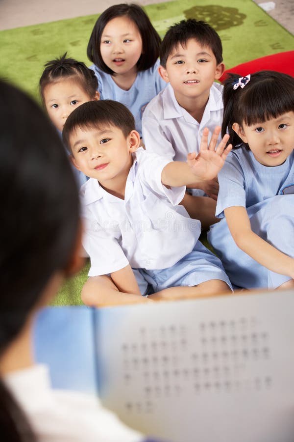 Insegnante che legge all'aula degli allievi immagini stock Insegnante che legge all'aula degli allievi immagini stock