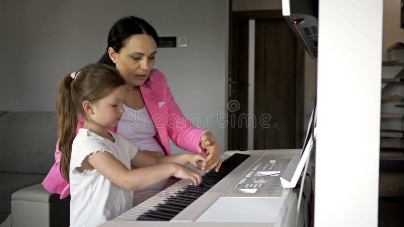 Insegnante di pianoforte che dà lezione a una ragazzina.