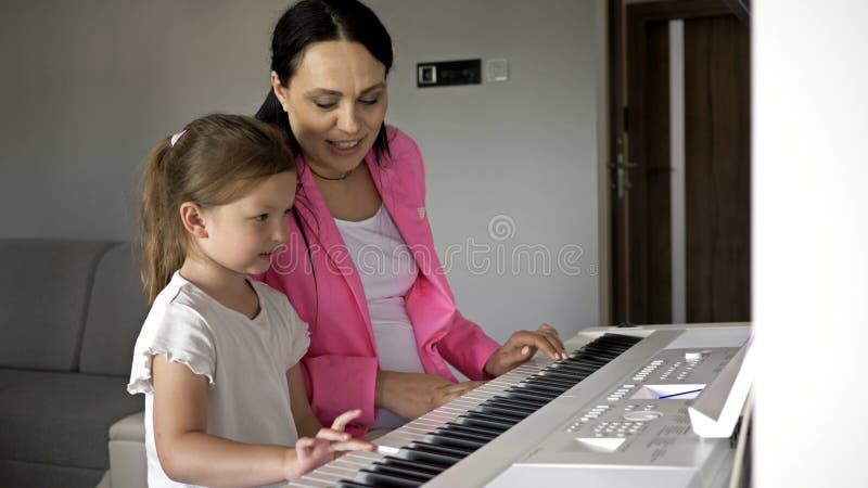 Insegnante di pianoforte che dà lezione a una ragazzina.