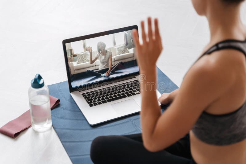 Insegnante di yoga che conduce una lezione virtuale sul laptop