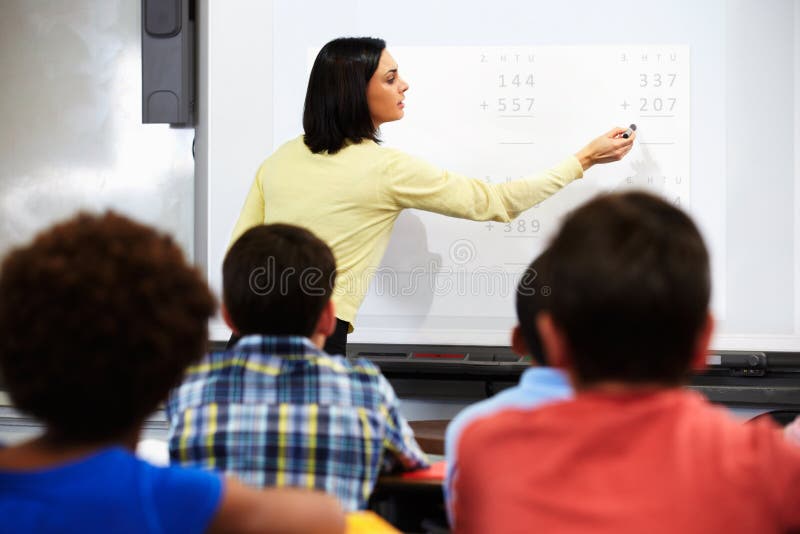 Insegnante Standing In Class che usando lavagna interattiva Insegnante Standing In Class che usando lavagna interattiva