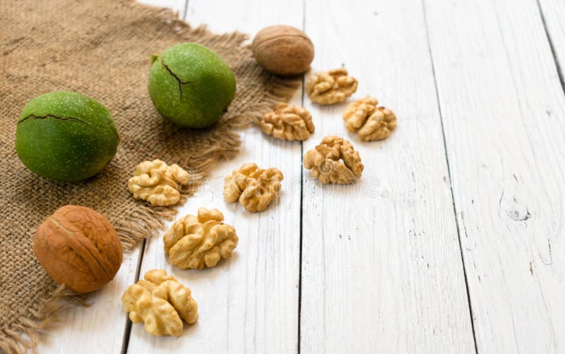 Inshell walnuts and walnut kernels on a white wooden table. The concept of a healthy diet. stock image Inshell walnuts and walnut kernels on a white wooden table. The concept of a healthy diet. stock image
