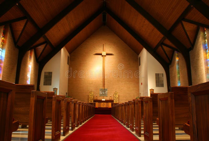 Vo vnútri veľký, moderný kostol s lavíc a kríž viditeľné.