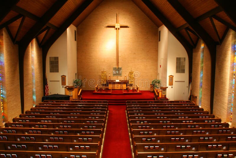 Inside of a large, modern church. View is from the balcony of the church and all the pews and hymnals are visible. Inside of a large, modern church. View is from the balcony of the church and all the pews and hymnals are visible.