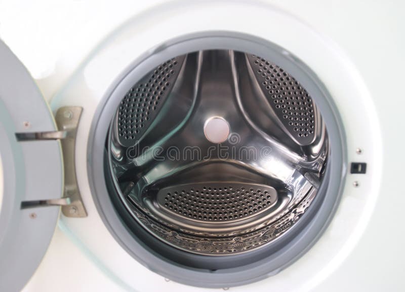 View of a modern front-loading washing machine drum, with clean, shiny stainless steel surface. The appliance represents household chores, laundry hygiene, and modern home technology. Metal steel drum stock images, royalty-free photos and pictures