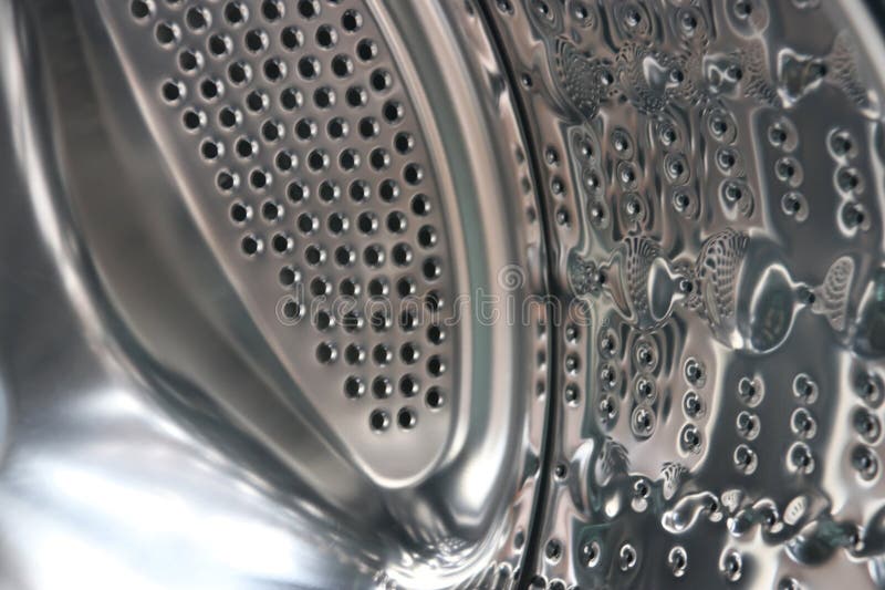 View of a modern front-loading washing machine drum, with clean, shiny stainless steel surface. The appliance represents household chores, laundry hygiene, and modern home technology. Metal steel drum stock images, royalty-free photos and pictures