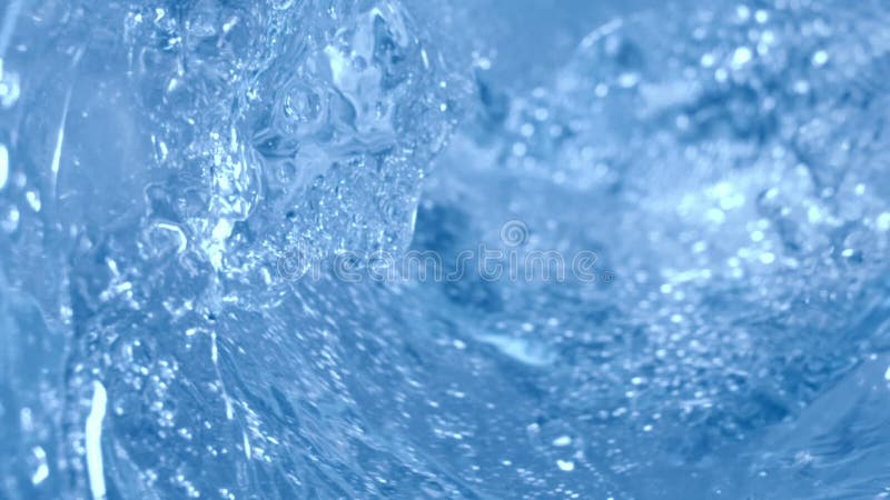 Inside of a glass of sparkling water with splashes macro shot with slow motion camera