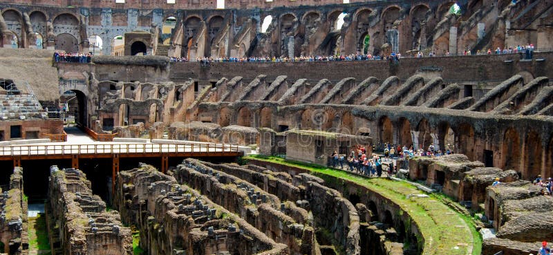 Ruins of the 2,000 year old Roman Colosseum still stand tall in Rome, Italy. A hot summer day under a blazing sun. This historic landmark draws thousand of visitors daily. Ruins of the 2,000 year old Roman Colosseum still stand tall in Rome, Italy. A hot summer day under a blazing sun. This historic landmark draws thousand of visitors daily.