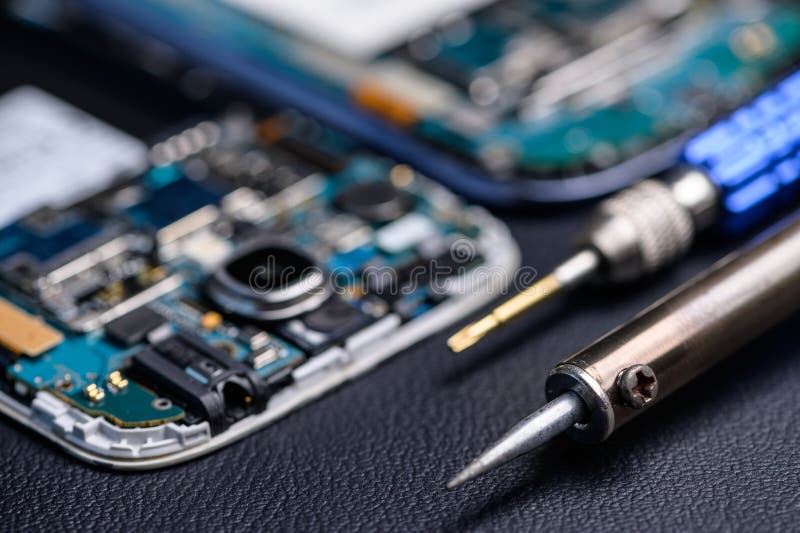 The inside of the smartphone`s motherboard and tools lay on the back table. the concept of computer hardware, mobile phone, electr royalty free stock photography