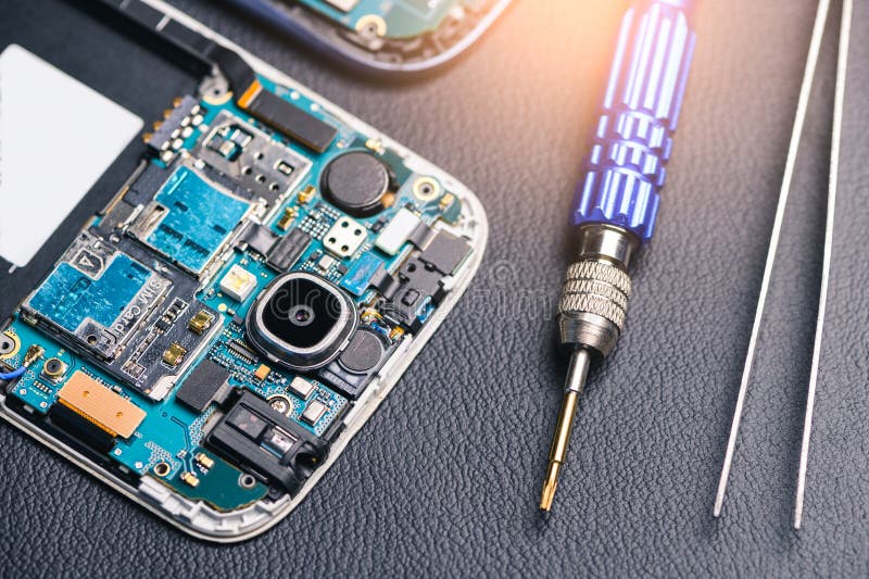 The inside of the smartphone`s motherboard and tools lay on the back table. the concept of computer hardware, mobile phone, electr royalty free stock photography