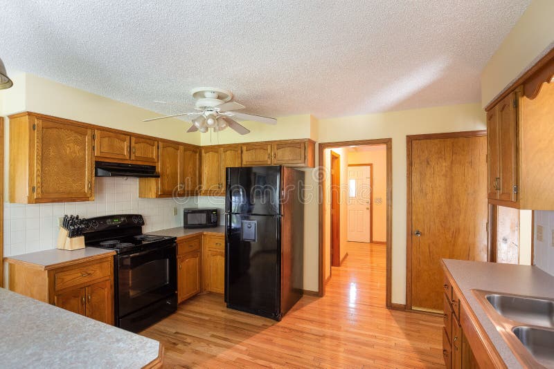 Inside View of a Cozy Modern Kitchen with a Table, Black Fridge, and