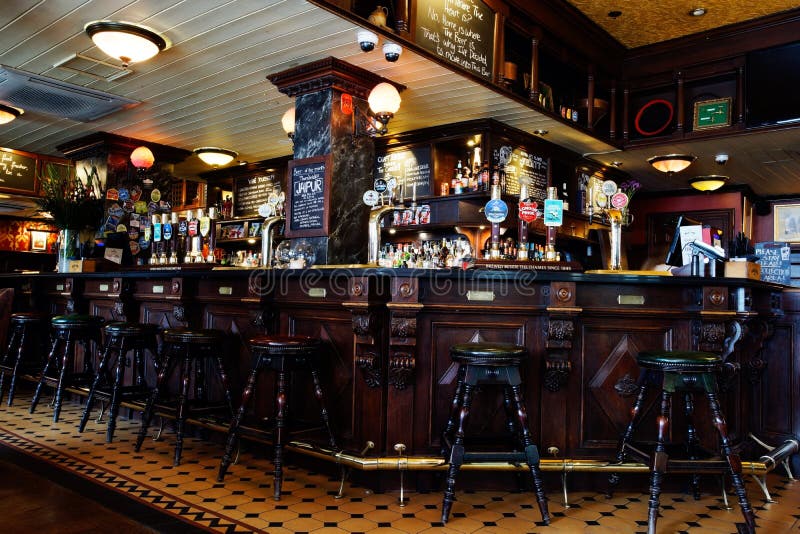 LONDON - April 26: Interior of pub, for drinking and socializing, focal point of the community, on April 26, 2017, London, UK. Pub business, now about 53,500 pubs in UK, has been declining every year. LONDON - April 26: Interior of pub, for drinking and socializing, focal point of the community, on April 26, 2017, London, UK. Pub business, now about 53,500 pubs in UK, has been declining every year