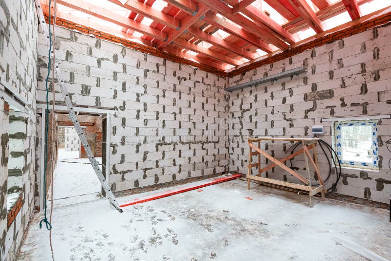 Inside view of working process of building house with wall made from foamed concrete block and wooden platform. Concept royalty free stock photos