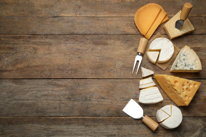 Insieme di formaggi diversi e di coltelli e forchette speciali su tavolette di legno, di stoffa piatta Spazio per il testo fotografie stock