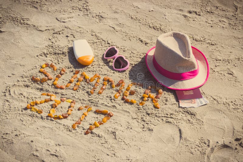 Inskriftsommar 2017, tillbehör för att solbada och pass med valutaeuro på sand på stranden, sommartid royaltyfria foton Inskriftsommar 2017, tillbehör för att solbada och pass med valutaeuro på sand på stranden, sommartid royaltyfria foton