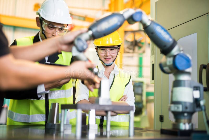 Inspector engineer check lathe robot machine. Waist up female inspector and Factory engineer manager check automatic lathe machine robot hand to milling spare royalty free stock image Inspector engineer check lathe robot machine. Waist up female inspector and Factory engineer manager check automatic lathe machine robot hand to milling spare royalty free stock image