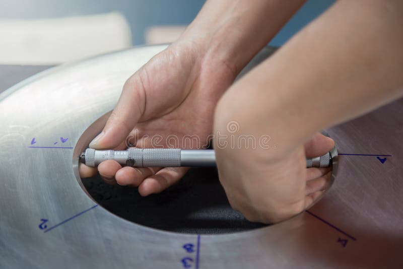 Inspector specialist using micrometer measure inside orifice stainless steel plate to check bore diameter for annual inspection royalty free stock photo