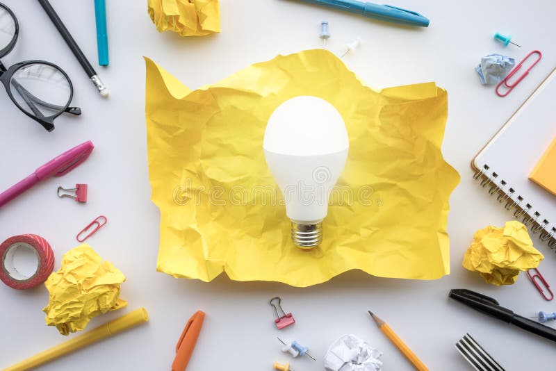 Inspiration creativity concepts with lightbulb in paper crumpled ball on worktable. Business ideas solution and human performance royalty free stock photography
