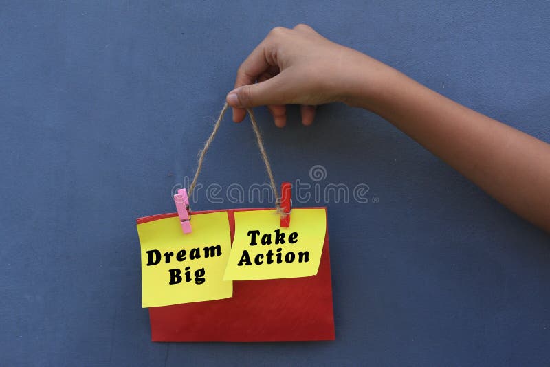 Inspirational quote - Dream big. Take action. With young girl holding origami paper notes rope hanging on wall. stock images Inspirational quote - Dream big. Take action. With young girl holding origami paper notes rope hanging on wall. stock images