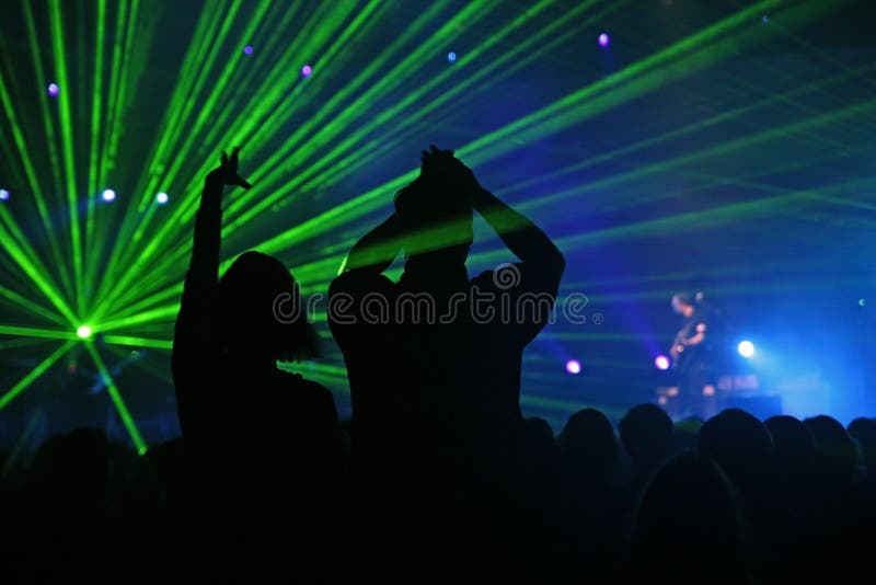 Siluety z žhavý pár na hudobný koncert s nádherným laser show.