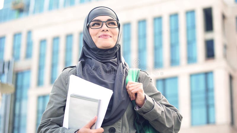 Inspirowany młody żeński uczeń jest ubranym hijab ono uśmiecha się, stojący outdoors na kampusie zdjęcia royalty free Inspirowany młody żeński uczeń jest ubranym hijab ono uśmiecha się, stojący outdoors na kampusie zdjęcia royalty free