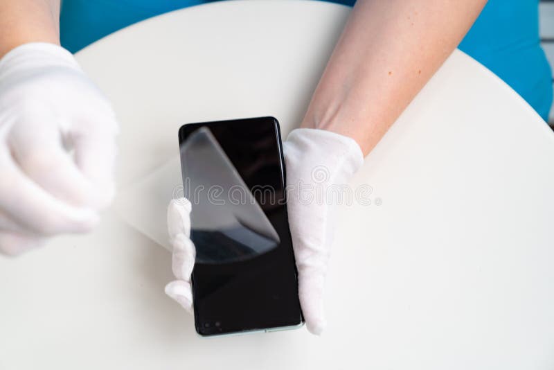 Installation of protective cover film on the smartphone. Maintenance support and repairing service concept. Installation of protective cover film on the smartphone. Maintenance support and repairing service concept.