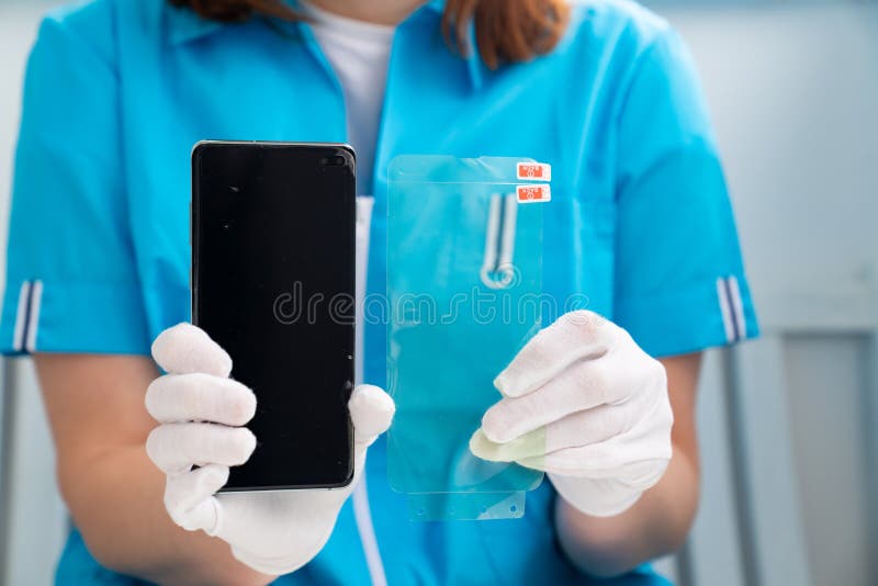 Installation of protective cover film on the smartphone. Maintenance support and repairing service concept. in woman hands. Installation of protective cover film on the smartphone. Maintenance support and repairing service concept. in woman hands.