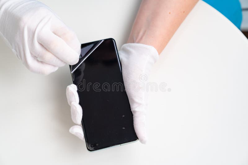 Installation of protective cover film on the smartphone. Maintenance support and repairing service concept. Installation of protective cover film on the smartphone. Maintenance support and repairing service concept.