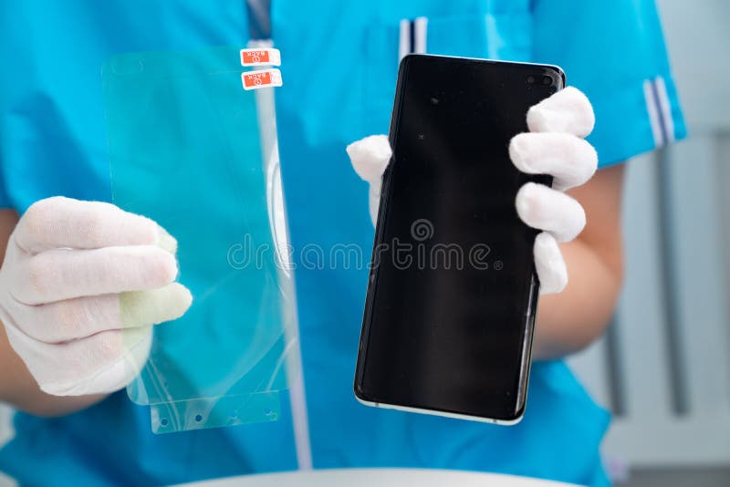 Installation of protective cover film on the smartphone. Maintenance support and repairing service concept. in woman hands. Installation of protective cover film on the smartphone. Maintenance support and repairing service concept. in woman hands.