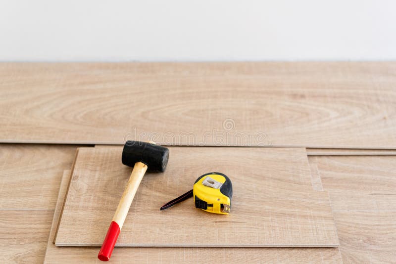 Instalación del entarimado laminado en interior En herramientas del carpintero de la mentira del piso las diversas Martillo y cin imagen de archivo Instalación del entarimado laminado en interior En herramientas del carpintero de la mentira del piso las diversas Martillo y cin imagen de archivo