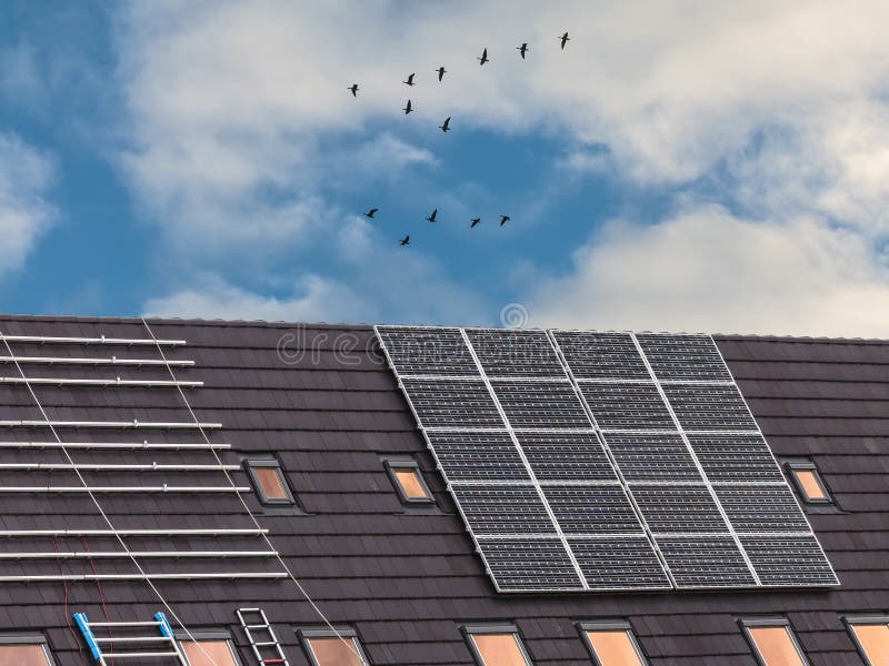A instalação dos painéis solares novos em telhados fotografia de stock A instalação dos painéis solares novos em telhados fotografia de stock