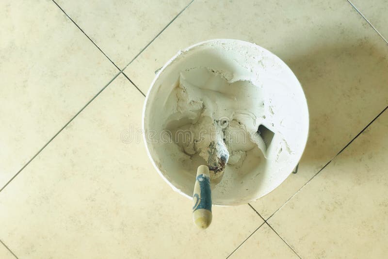 Installation of Ceramic Tiles.Tile Glue is Mixed in a Plastic Bucket