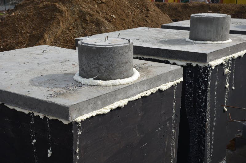 Installation of concrete tanks painted with black insulating asphalt paint. the ring entrances look over the terrain otherwise eve