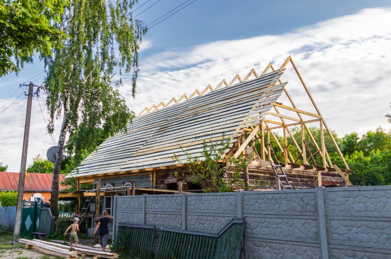 Installation d'un nouveau toit en bois sur une maison de demeure par une équipe de menuisiers et de roofers photos libres de droits Installation d'un nouveau toit en bois sur une maison de demeure par une équipe de menuisiers et de roofers photos libres de droits