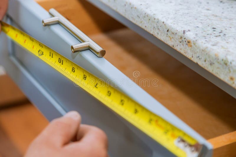 Installation of drawers handles on kitchen cabinets