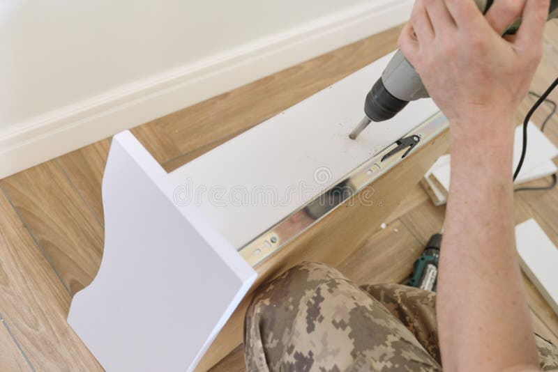Installation of furniture. Closeup of workers hand with professional tools and furniture details royalty free stock photo Installation of furniture. Closeup of workers hand with professional tools and furniture details royalty free stock photo