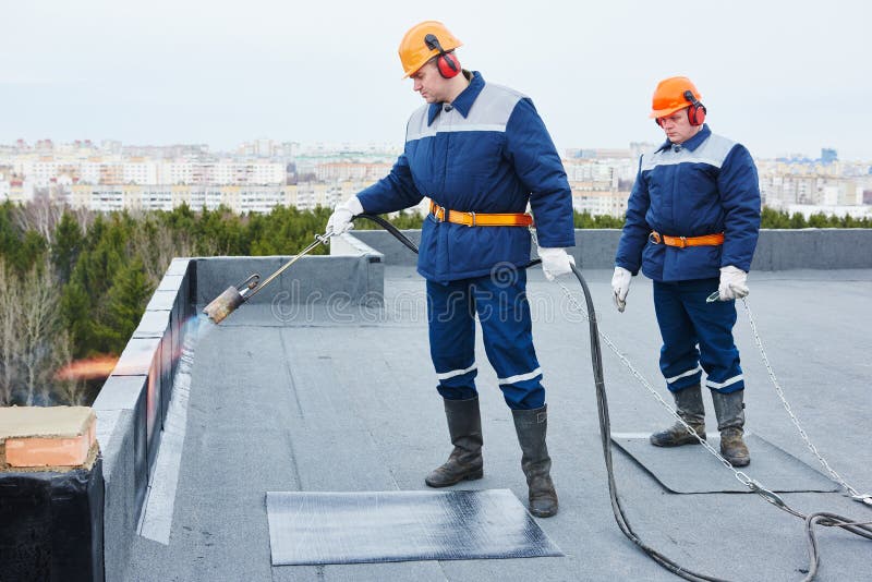 Installation för plant tak Värma och smältande bitumen som taklägger filt arkivbild Installation för plant tak Värma och smältande bitumen som taklägger filt arkivbild