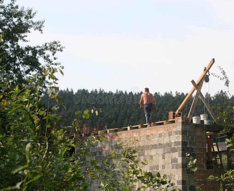 Installation of the house. The builder works on the roof. Brick laying. Bricklayer tiler stock images, royalty-free photos and pictures