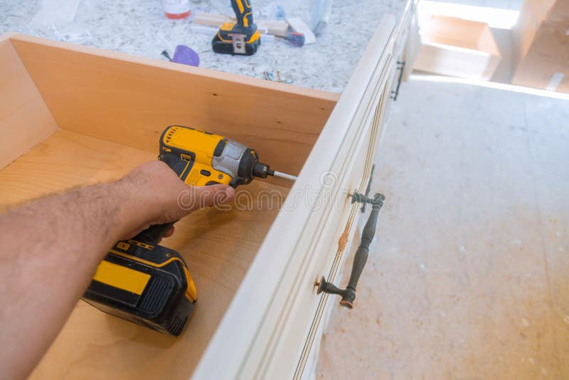 Installation of drawers handles on kitchen cabinets