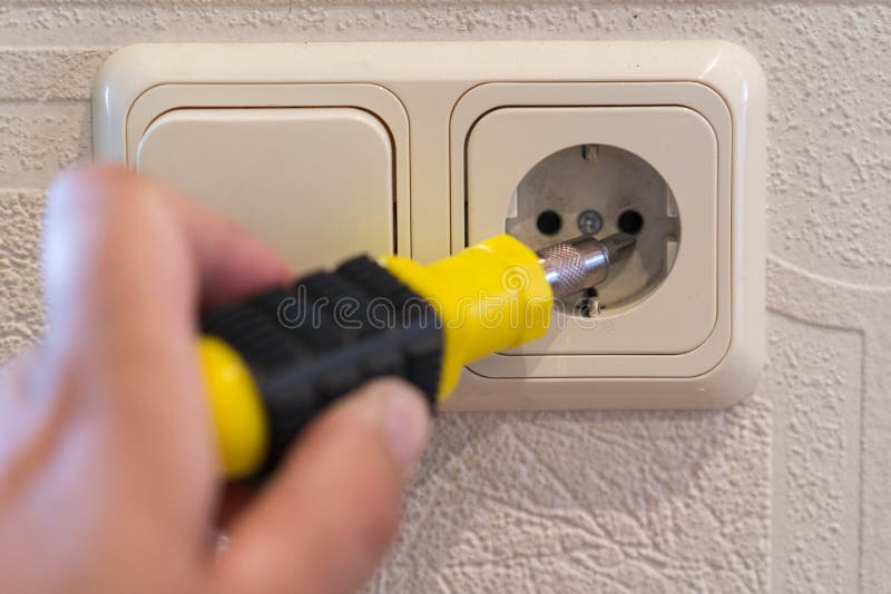 Installazione degli incavi di potere della parete Primo piano della mano dell'elettricista dell'uomo che ripara uno sbocco elettr immagine stock libera da diritti Installazione degli incavi di potere della parete Primo piano della mano dell'elettricista dell'uomo che ripara uno sbocco elettr immagine stock libera da diritti